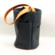 sac seau en cuir bleu et orange, doublure wax, vue de profil, la doublure n'est pas apparente